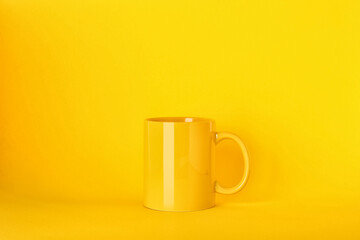 New blank ceramic mug on yellow background