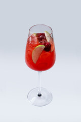 A glass of spanish sangria made of red wine and fresh berries, red cocktail on light background