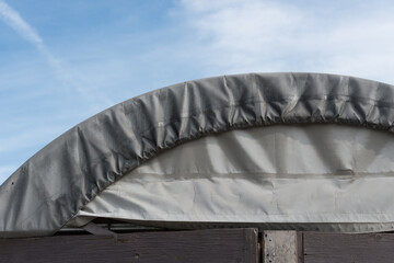 close up of a tarpaulin covered shed and blue sky