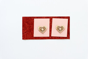 wooden heart shapes on red and pink paper squares