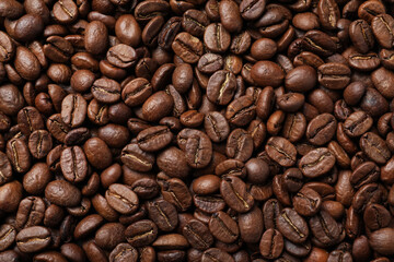 Pile of roasted coffee beans as background, top view