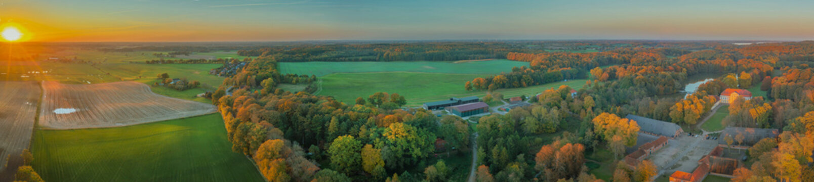 Aerial view of countrysidewith of picturesque manor house and expansive English style landscaped park at the estate Emkendorf in autumn by sunset, Emkendorf, Rendsburg-Eckernförde, Schleswig-Holstein 