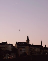 Fototapeta premium luxembourg old town in sunset with birds flying over the city