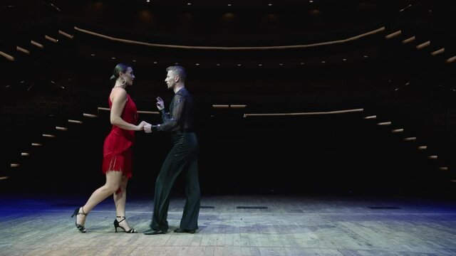 Ballroom couple on stage in blue tones. Elegant dancers, ballroom dancing on the stage of the theater.