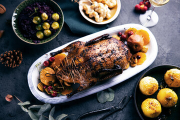 Köstlich angerichtetes Fleisch mit Beilagen auf rustikalem HIntergrund. Ente oder Gans auf einem Weihnachtstisch.