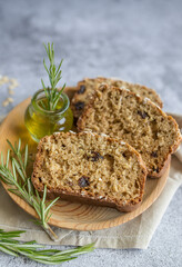 oat bread  slices with rosemary on grey background