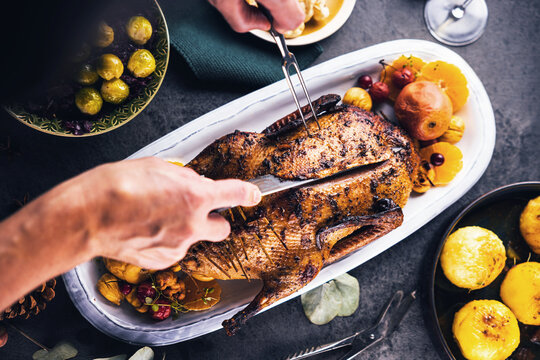 Mann schneidet k&ouml;stlich angerichtetes Fleisch f&uuml;r ein Abendessen.