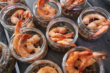 Delicious fresh seafood, shrimp with fresh vegetables. buffet table with lots of delicious snacks. canapes, bruschetta, and little desserts on wooden plate board