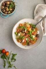 salmon, arugula and couscous salad on grey background