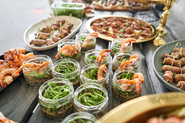 The waiter sets the table. Delicious fresh seafood, shrimp with fresh vegetables. buffet table with lots of delicious snacks.