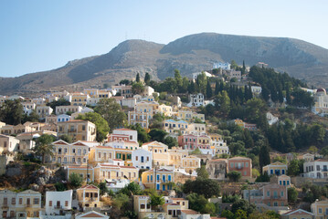 Fototapeta na wymiar Beautiful Symi island, Greece. View of neo classical houses on a hillside. Landscape view