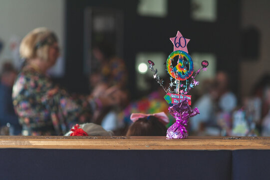 Hippy themed 60th birthday decoration - Celebration party in the background with unrecognisable person with fancy dress. Copy space