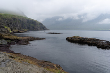 Beautiful aerial view of Faroe Islands Towns next to the ocean Canals, and boats and massive mountains. 