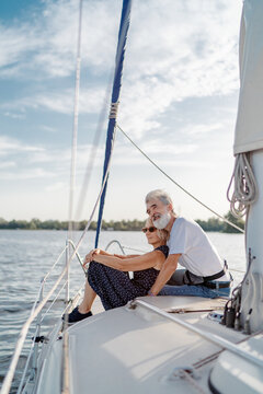 Romantic vacation and luxury travel. Senior loving couple sitting on the yacht deck. Sailing the river.