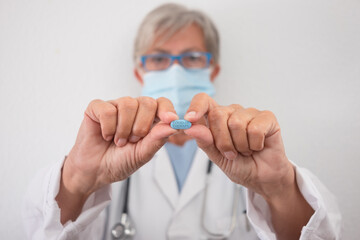 Female doctor holding the new covid antiviral pill who can halve risk of hospitalisation. This pill may cut numbers of people in hospital about a half