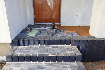 Kostka brukowa. Układanie kostki brukowej, palisad betonowych, obrzeży, wejście do domu. Paving. Laying paving stones, concrete palisades, edging, entrance to the house. © jarizPJ