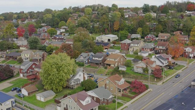 A slow forward moving aerial establishing shot of a typical western Pennsylvania residential neighborhood in the Autumn season. Pittsburgh suburbs.  	