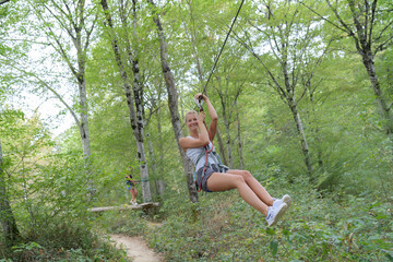 portrait of woman sliding down zip wire