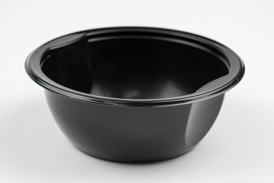 Empty black plastic dish for food isolated on grey background