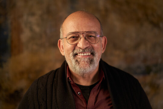 Portrait of a middle-aged Caucasian smiling man looking at camera. Look of an older person
