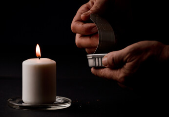 concept of energy blackout, lit candle, with can of preserves in man's hands, energy poverty....