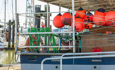 Buoys tied to back side of a fishing boat. Colorful buoys hanging on a fishing boat