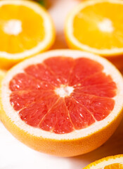 Fototapeta na wymiar sliced oranges and grapefruits on a white table, top view, fruit background. High quality photo