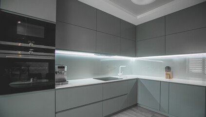 Modern fully fitted kitchen with kitchen appliances in grey and white