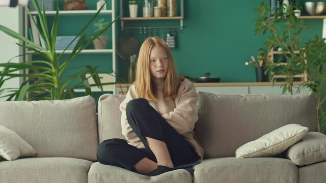 A Depressed Teenage Girl Looks at the Phone, is Sad, Afraid of Bullying On Social Networks. Stress, Online Bullying, Cyberbullying, Psychological Abuse.