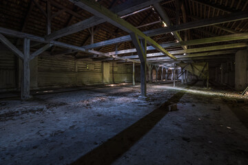 Fototapeta na wymiar inside dark abandoned ruined wooden decaying hangar with rotting columns