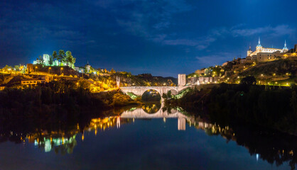 Fototapeta na wymiar Night Panoramic view of the Alcázar de Toledo and the Castillo de San Servando across the Alcantara Bridge