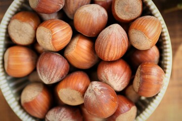 ripe hazelnuts close-up in a round cup on a wooden table.Vegetable protein source. Healthy fats. Farmed organic ripe hazelnuts