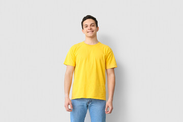 Fototapeta premium Handsome young man in stylish t-shirt on light background