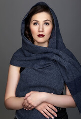 Beauty portrait of brunette woman dressed in dark blue scarf.