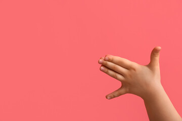 Child performing a shadow play on color background