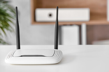 Modern wi-fi router on table in office