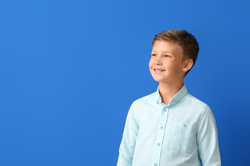 Smiling little boy in shirt on blue background