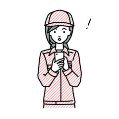 立ってスマートフォンを操作して何かに気づいて驚いた作業員の女性