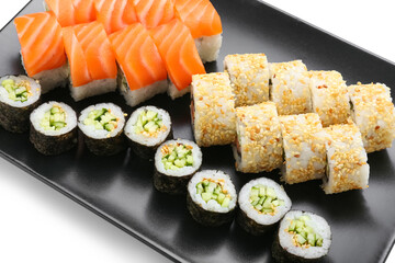Plate with delicious sushi rolls on white background