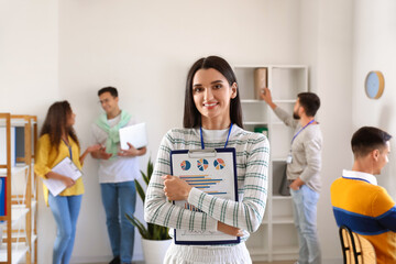 Beautiful woman with clipboard in office