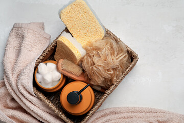 Basket with bath supplies on light background