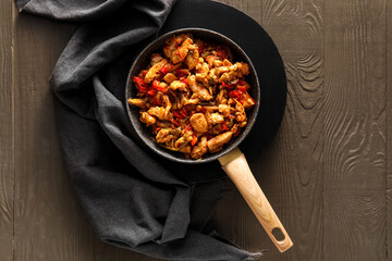 Frying pan with delicious chicken Fajita on color wooden background