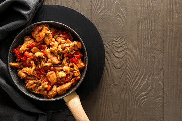 Frying pan with tasty chicken Fajita on color wooden background