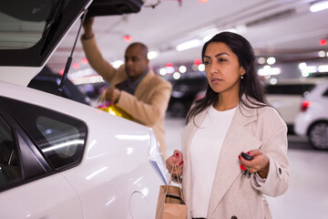 Fototapeta premium Adult woman with gift bags in underground parking lot