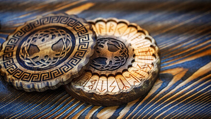 Fototapeta na wymiar Blurred runes in a round wooden carved box on the table. Esoteric concept