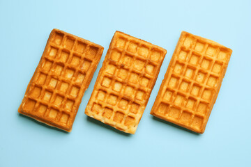 Tasty Belgian waffles on blue background