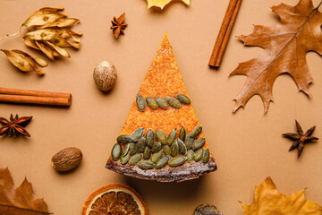Composition with piece of delicious pumpkin pie on brown background