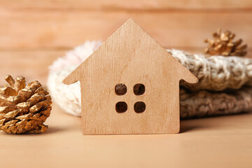 House figure with fir cone on wooden background, closeup. Winter concept