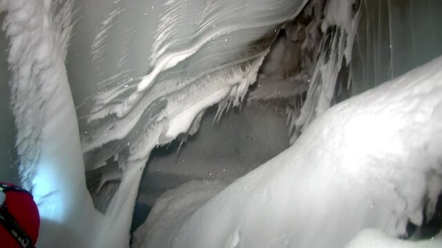Svalbard, Norway - 12 May 2010: People tourist cave in Arctic. Hollow place in in glacier. Eternal Frost. North Pole. Beautiful unique background. Ice desert landscape. Quiet of wilderness.