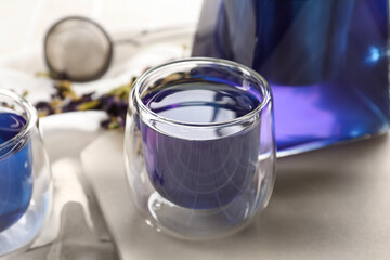 Glass cup of blue tea on table, closeup